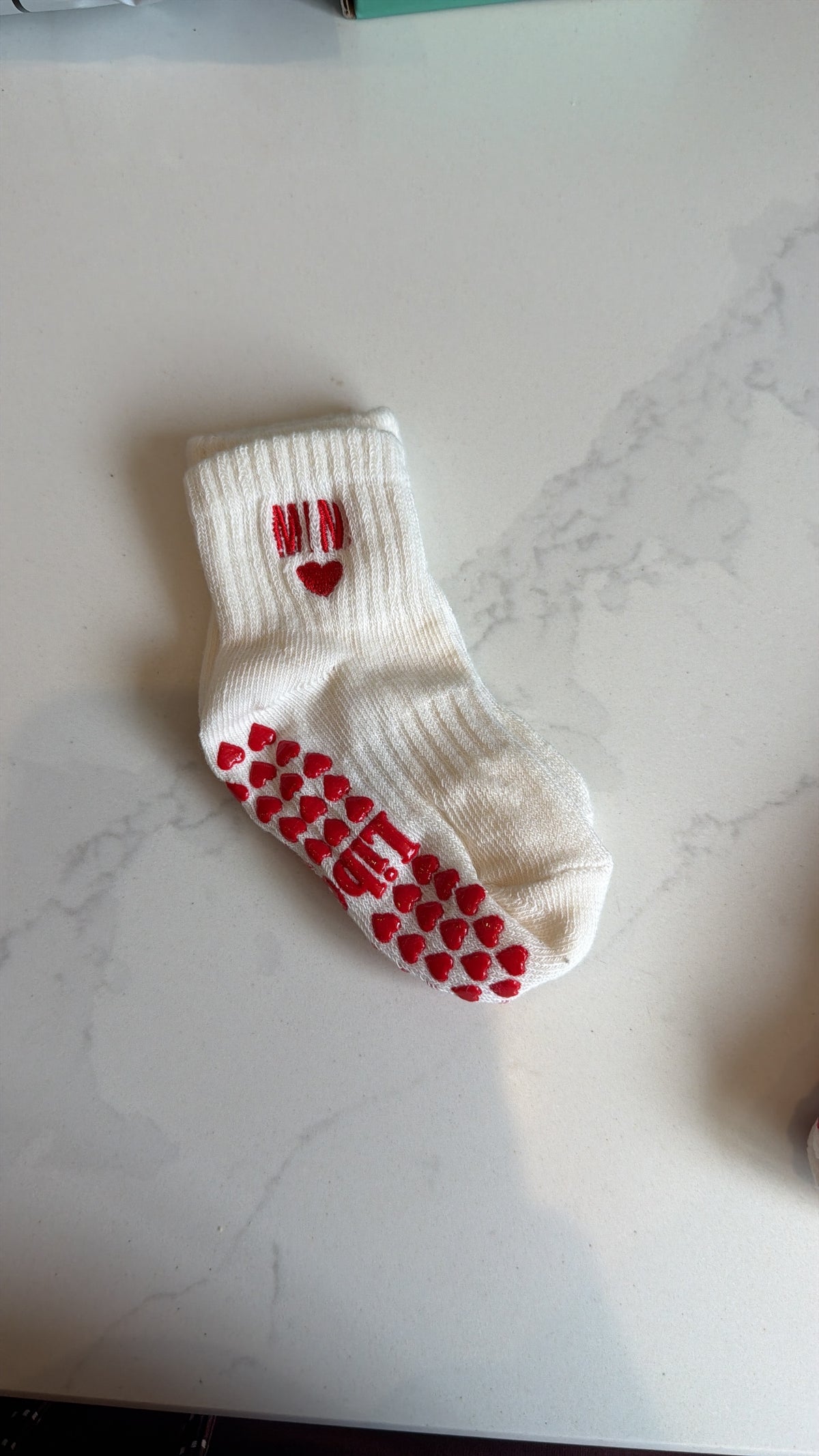 White Mini grip sock with red heart-shaped grips and Mini embroidery